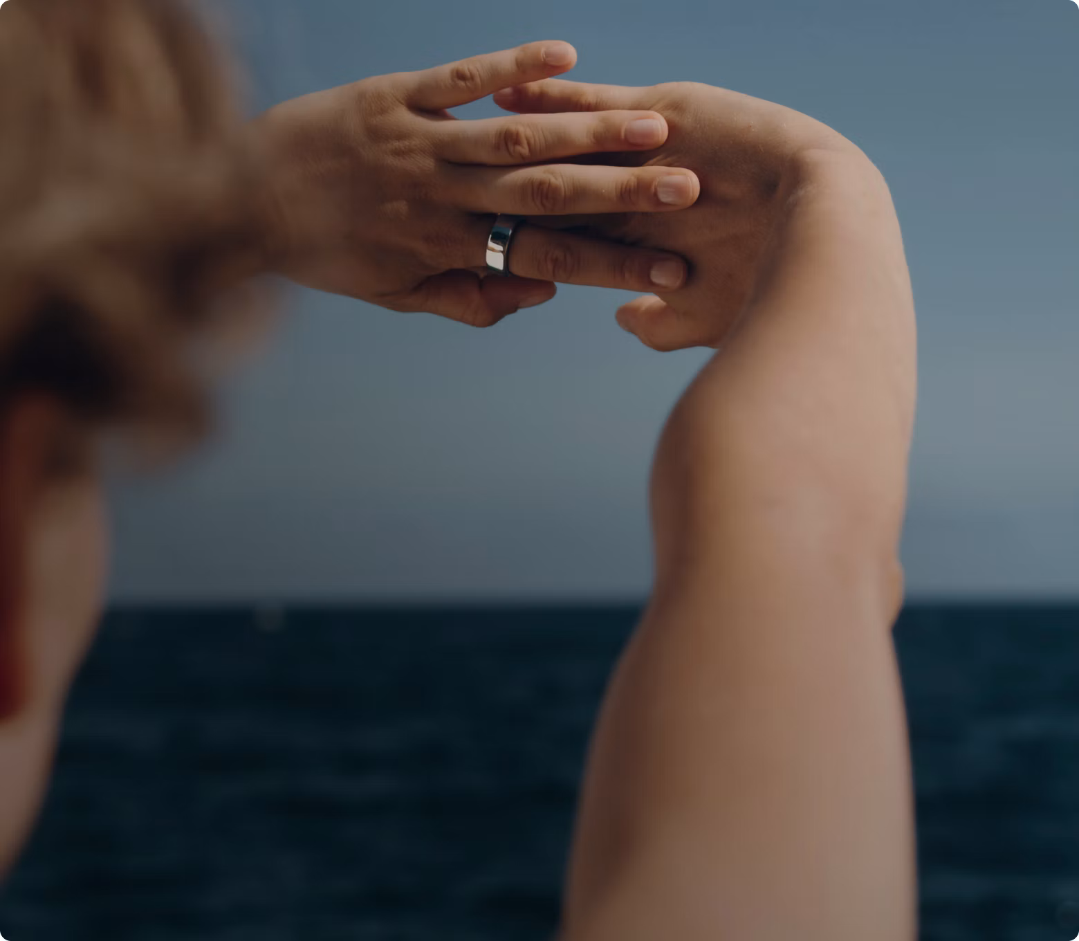 Woman wearing Oura ring stretching hands above head