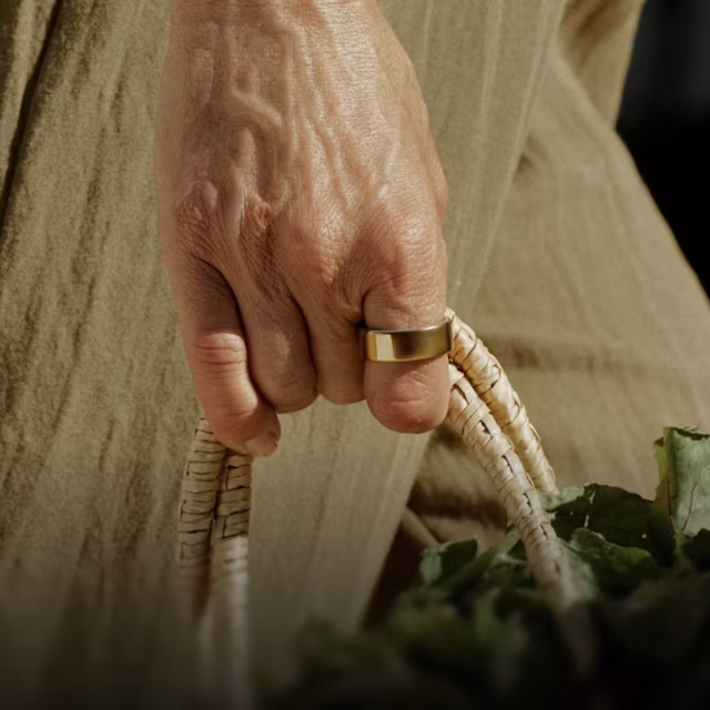 Close up of a person's hand with a Gold Oura Ring 4 on their finger
