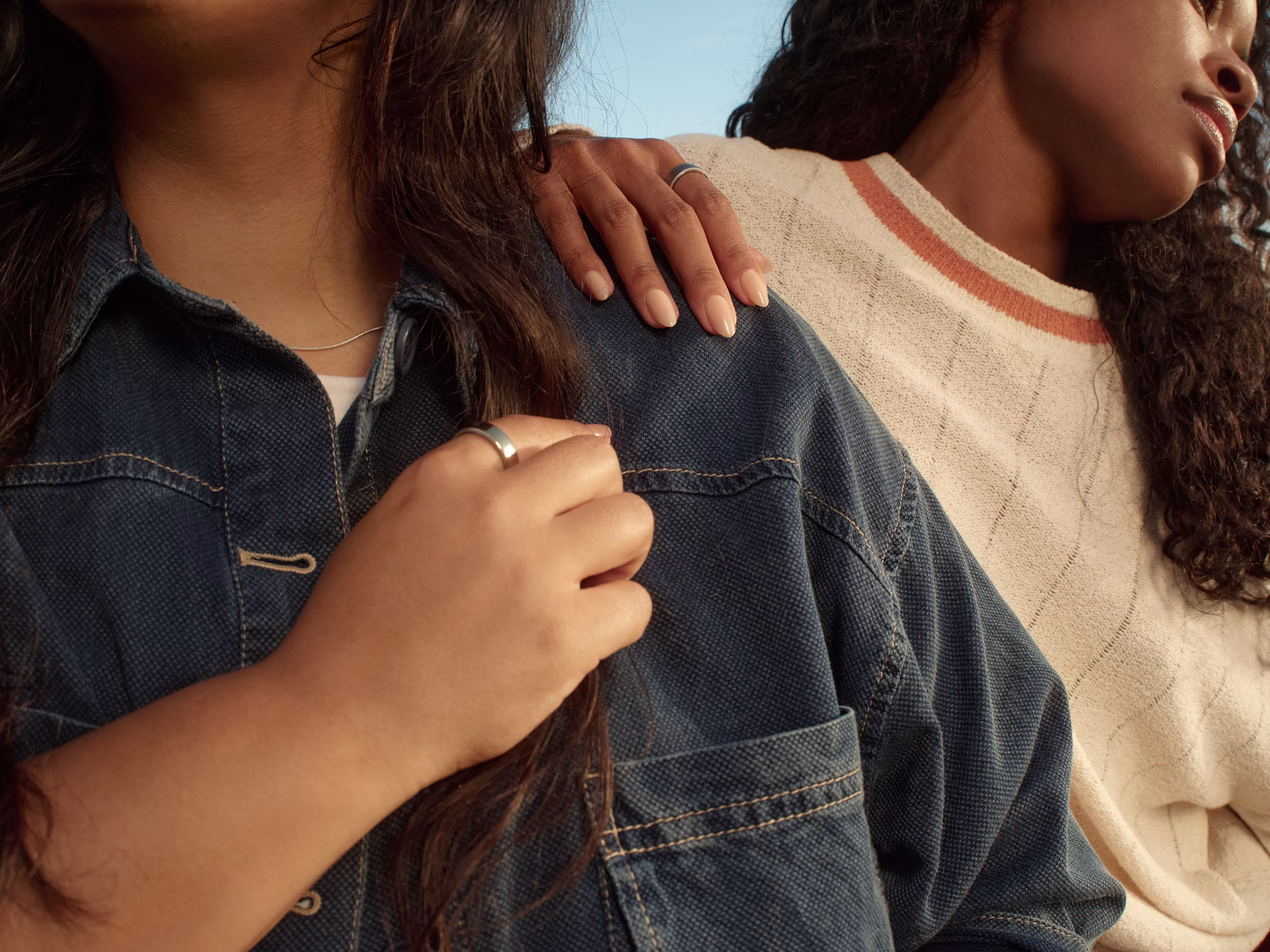 Two women standing side by side, one in a denim jacket wearing a Silver Oura Ring.